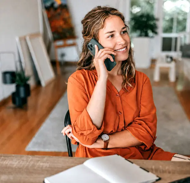 Woman smiling during a live phone psychic reading with an AskNow advisor.