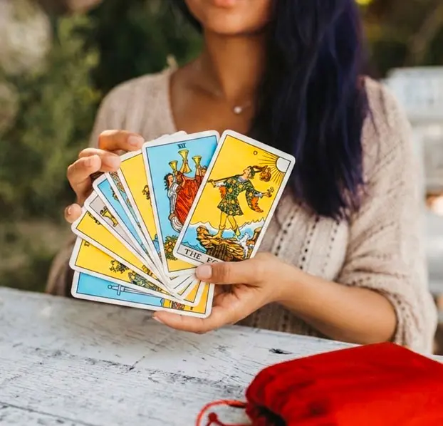 Psychic giving a tarot card reading at a table.